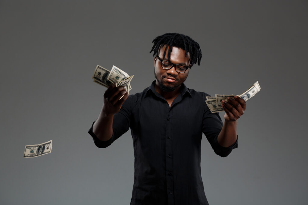 Jonge succesvolle Afrikaanse zakenman die geld gooit